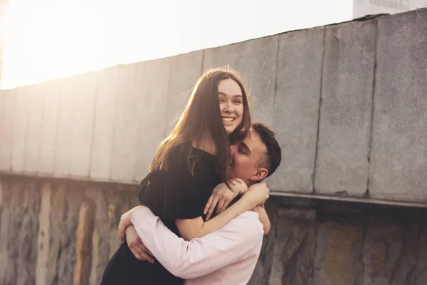 Happy young couple of friends, teenagers, students hugging, having fun at city street — Stock Photo, Image