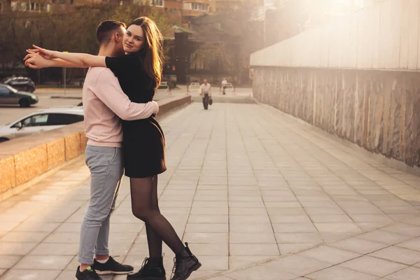 Feliz jovem casal de amigos, adolescentes, estudantes abraçando na rua da cidade — Fotografia de Stock
