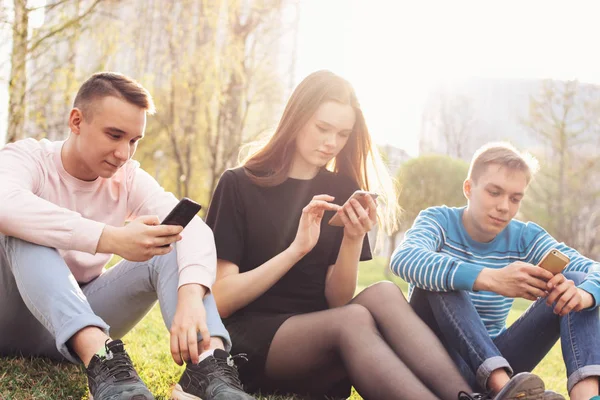 The group of young friends teenagers using mobile at the city street — Stock Photo, Image