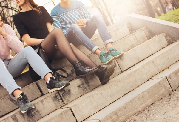 Снимок группы друзей Миллениалы студенты подростки сидят на городской улице, дружба, крупным планом фокусируются на ногах — стоковое фото