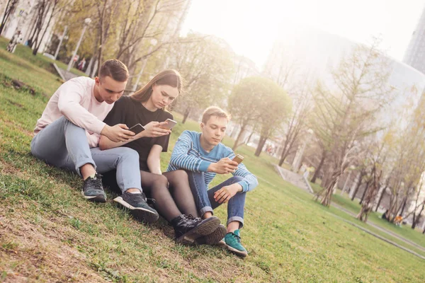 De groep van jonge vrienden tieners met behulp van mobiel in de stad straat — Stockfoto