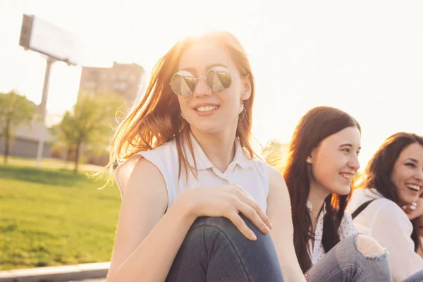 Group of young happy girls friends enjoy life on summer city street, sunset background — Stock Photo, Image