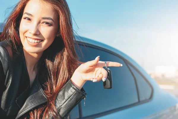 Happpy mooie charmante brunette lang haar jonge Aziatische vrouw in zwart lederen jas met autosleutel — Stockfoto