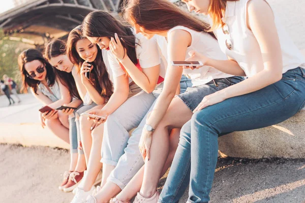 Group of young happy girls real friends students using mobile at city street on sunset background — Stock Photo, Image