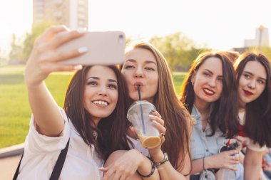 Yaz şehir caddesinde selfie yapan genç mutlu kaygısız kız arkadaşlar grubu, gün batımı zamanı arka plan