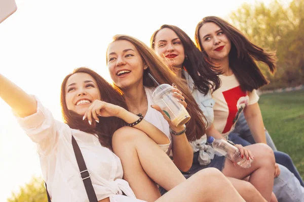 Yaz şehir caddesinde selfie yapan genç mutlu kaygısız kız arkadaşlar grubu, gün batımı zamanı arka plan