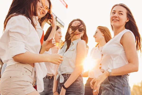 Grupo de belas namoradas despreocupadas dançando se divertir na rua da cidade no fundo do pôr do sol da noite, hora de verão — Fotografia de Stock