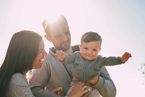 Famille heureuse avec bébé garçon mignon sur fond de ciel à l'extérieur, sensibilité au concept de la nature — Photo