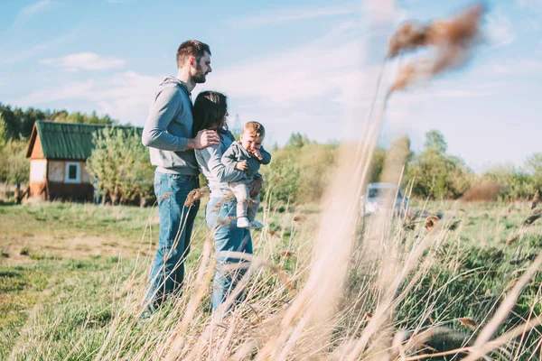 Szczęśliwa rodzina z cute baby boy na wsi Dom i charakter tła na zewnątrz, wrażliwość na naturę koncepcji — Zdjęcie stockowe