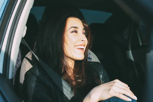 Happpy beautiful charming brunette long hair young asian woman in black leather jacket enjoing life in car window — Stock Photo, Image
