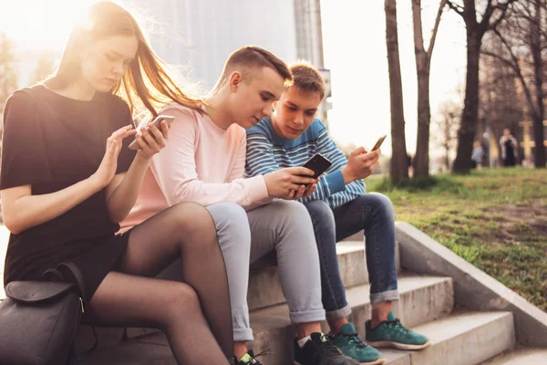 The group of young friends teenagers using mobile at city street — Stock Photo, Image