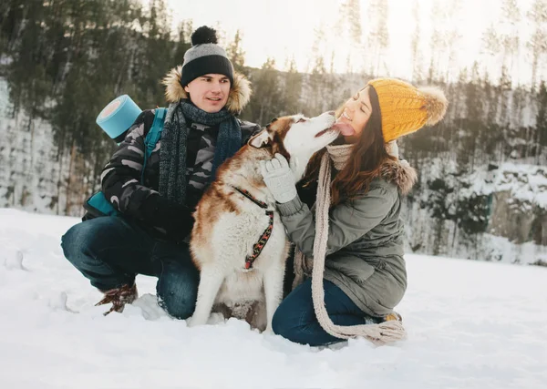 Το ευτυχισμένο ζευγάρι με το σκύλο Haski στο δασικό πάρκο φυσικού πάρκου σε κρύα εποχή. Ταξίδια περιπέτεια ιστορία αγάπης — Φωτογραφία Αρχείου