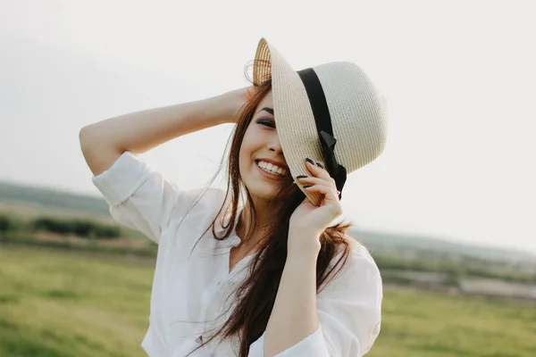 Портрет красивой беззаботной длинные волосы азиатской девушки в белой одежде и соломенной шляпе наслаждается жизнью в поле на закате. Чувствительность к природе — стоковое фото