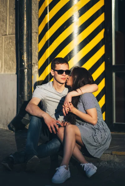 Giovane coppia innamorata adolescenti vestiti in stile casual seduti insieme sulla strada della città — Foto Stock