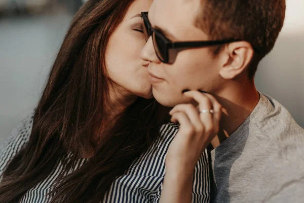 Happy young couple in love teenagers friends dressed in casual style kissing at street — Stock Photo, Image