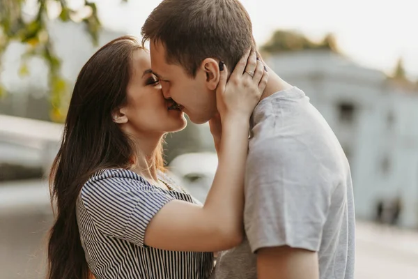 Feliz jovem casal apaixonado adolescentes amigos vestidos em estilo casual beijando na rua — Fotografia de Stock