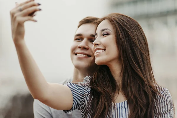 Feliz joven pareja enamorada adolescentes amigos vestidos con estilo casual haciendo selfie en la calle — Foto de Stock