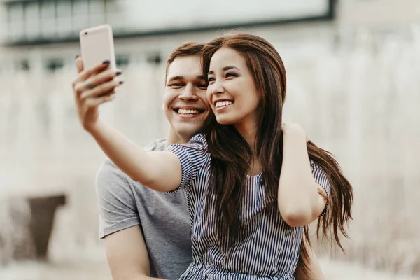 Happy young couple in love teenagers friends dressed in casual style making selfie at street — Stock Photo, Image
