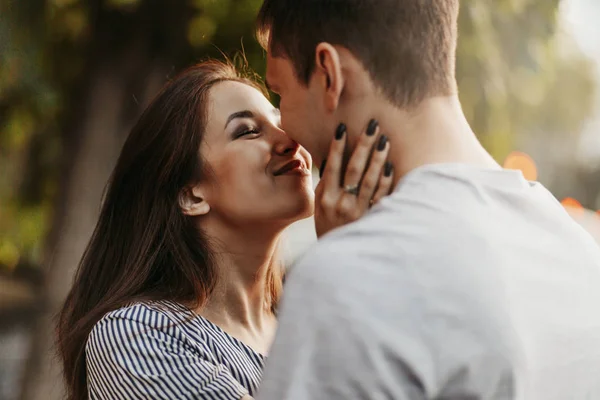 Happy young couple in love teenagers friends dressed in casual style kissing at street — Stock Photo, Image