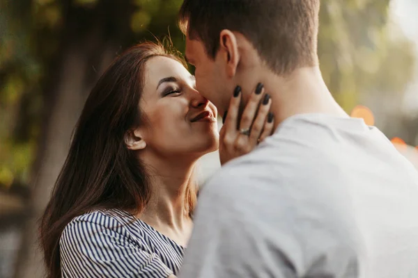 Feliz joven pareja enamorada adolescentes amigos vestidos con estilo casual besándose en la calle — Foto de Stock