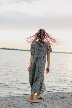 Sahilde elbise Afrika örgü ile güzel romantik genç kadın, arkadan görünüm, yaz tatil zamanı