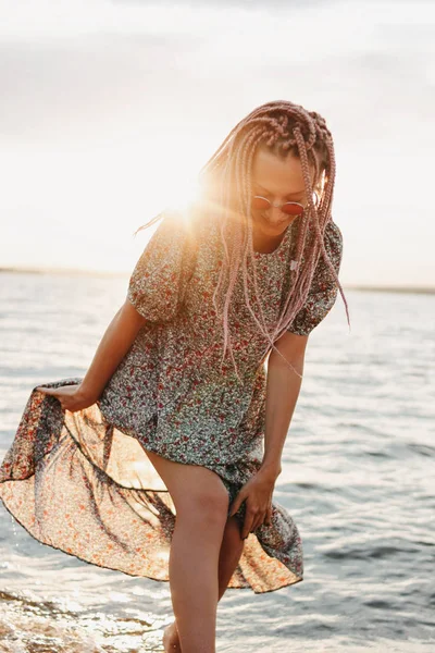 Jeune femme insouciante avec des tresses africaines en belle robe sur la plage, vacances d'été — Photo