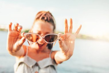 Güneş gözlüğü Afrika örgü ile portre mutlu kaygısız genç kadın yakın yukarı sahilde yaşam zevk, yaz tatil zamanı
