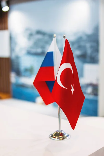 Russian and Turkish flags on metal stand on business conference or exhibition, international relations, trade, cooperation
