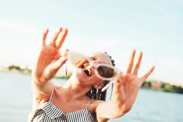 Jovem despreocupada feliz com tranças africanas em óculos de sol desfrutar da vida na praia, férias de verão — Fotografia de Stock