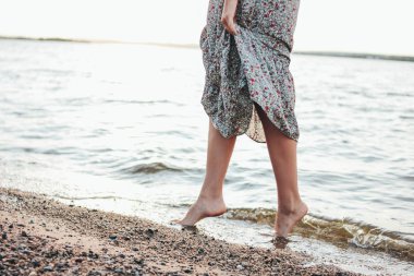 Plaj, yaz tatil zamanında elbise romantik genç kadın bacaklar kırpma fotoğrafı