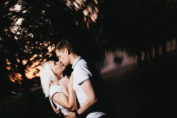 Jovem casal feliz no amor beijando na noite Park. Foto com efeitos de flash — Fotografia de Stock