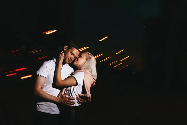 Mladý šťastný pár zamilovaný do noci líbal. Fotografie s efekty blesku — Stock fotografie