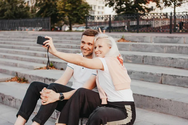 Joven feliz pareja en el amor haciendo selfie en la cámara retro en la calle de la ciudad — Foto de Stock