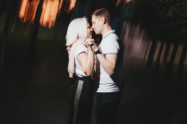 Jovem casal feliz no amor beijando na noite Park. Foto com efeitos de flash — Fotografia de Stock