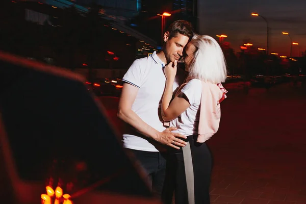 Jovem casal feliz no amor beijando na rua da cidade noite. Foto com efeitos de flash — Fotografia de Stock