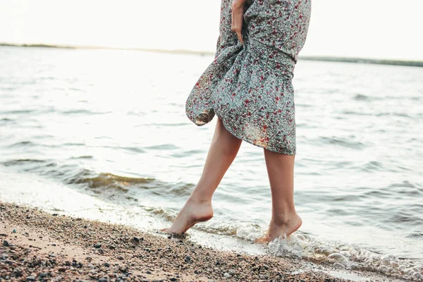 Ritaglio foto di gambe di romantica giovane donna in abito sulla spiaggia, tempo di vacanza estiva — Foto Stock