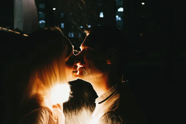 Jovem casal feliz no amor beijando à noite sob chuva. Foto com efeitos de flash — Fotografia de Stock