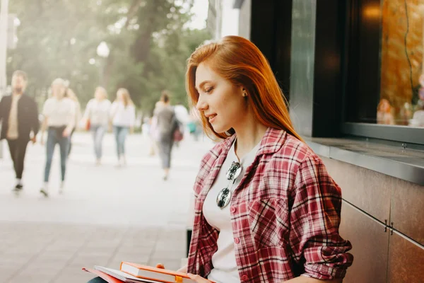 Attraktive rothaarige lächelnde Studentin in lässiger Kleidung auf der Straße in der Stadt — Stockfoto