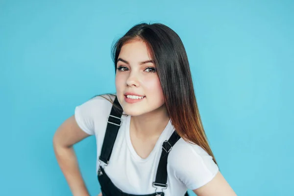 Affascinante ragazza sorridente con i capelli lunghi scuri in t-shirt bianca isolata su sfondo blu — Foto Stock