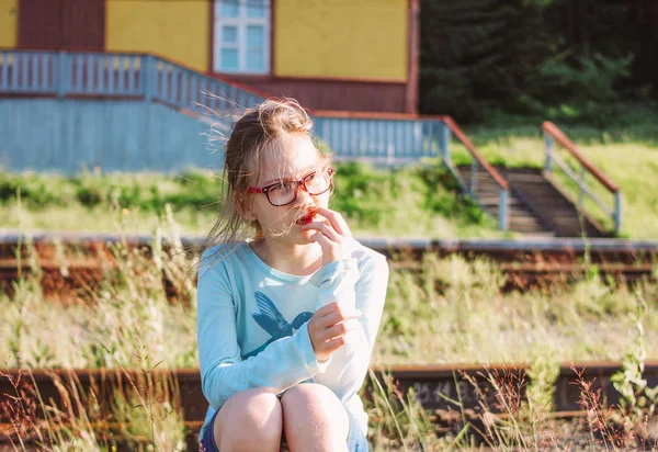 Retrato de la encantadora chica sonriente en gafas en el fondo del ferrocarril, hora de verano en el campo —  Fotos de Stock