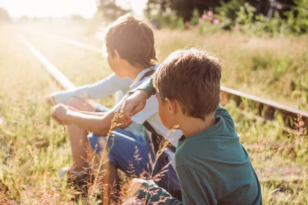 Grupo de niños preadolescentes en el ferrocarril al atardecer, hora de verano en el campo —  Fotos de Stock