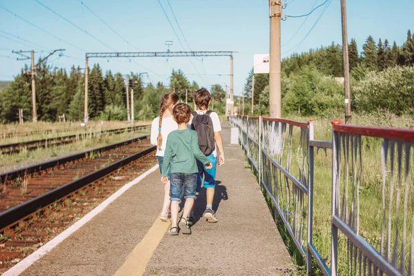 Groupe d'enfants tweens marchant le long de l'ancien chemin de fer, heure d'été à la campagne — Photo