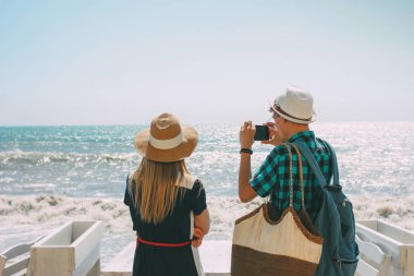 Çift kadın ve adam görünümlü ve fırtınalı denizde fotoğraf yapma
