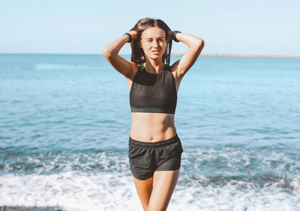 Молодая стройная спортивная длинные волосы чувственная женщина в спортивной одежде на морском пляже, здоровый образ жизни — стоковое фото