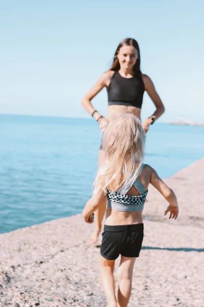 Petite fille mignonne courir pour adapter maman sur la plage, mode de vie sain, sport famille — Photo