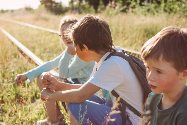 Groupe d'enfants tweens sur le chemin de fer au coucher du soleil, heure d "été à la campagne — Photo