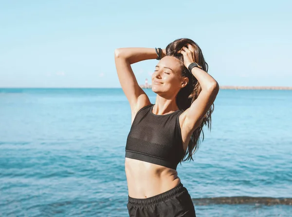 Joven delgado atlético pelo largo sensual mujer en ropa deportiva en la playa del mar por la mañana, estilo de vida saludable — Foto de Stock