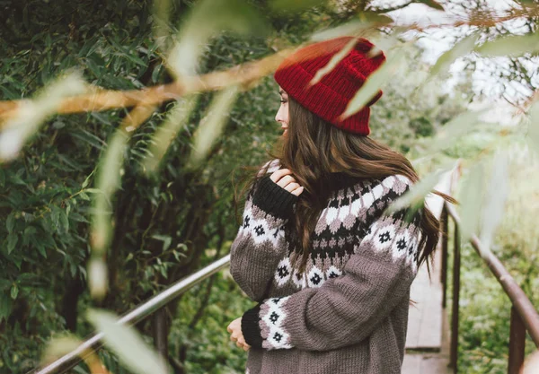 Длинные волосы, девушка в красной шапке и вязаном нордическом свитере в осеннем природном парке, приключенческий образ жизни в путешествиях — стоковое фото