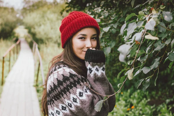 Длинные волосы, девушка в красной шапке и вязаном нордическом свитере в осеннем природном парке, приключенческий образ жизни в путешествиях — стоковое фото