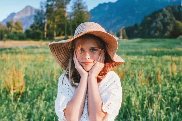 Mooie romantische Preteen meisje in stro hoed tegen achtergrond van bergen, gouden uur — Stockfoto